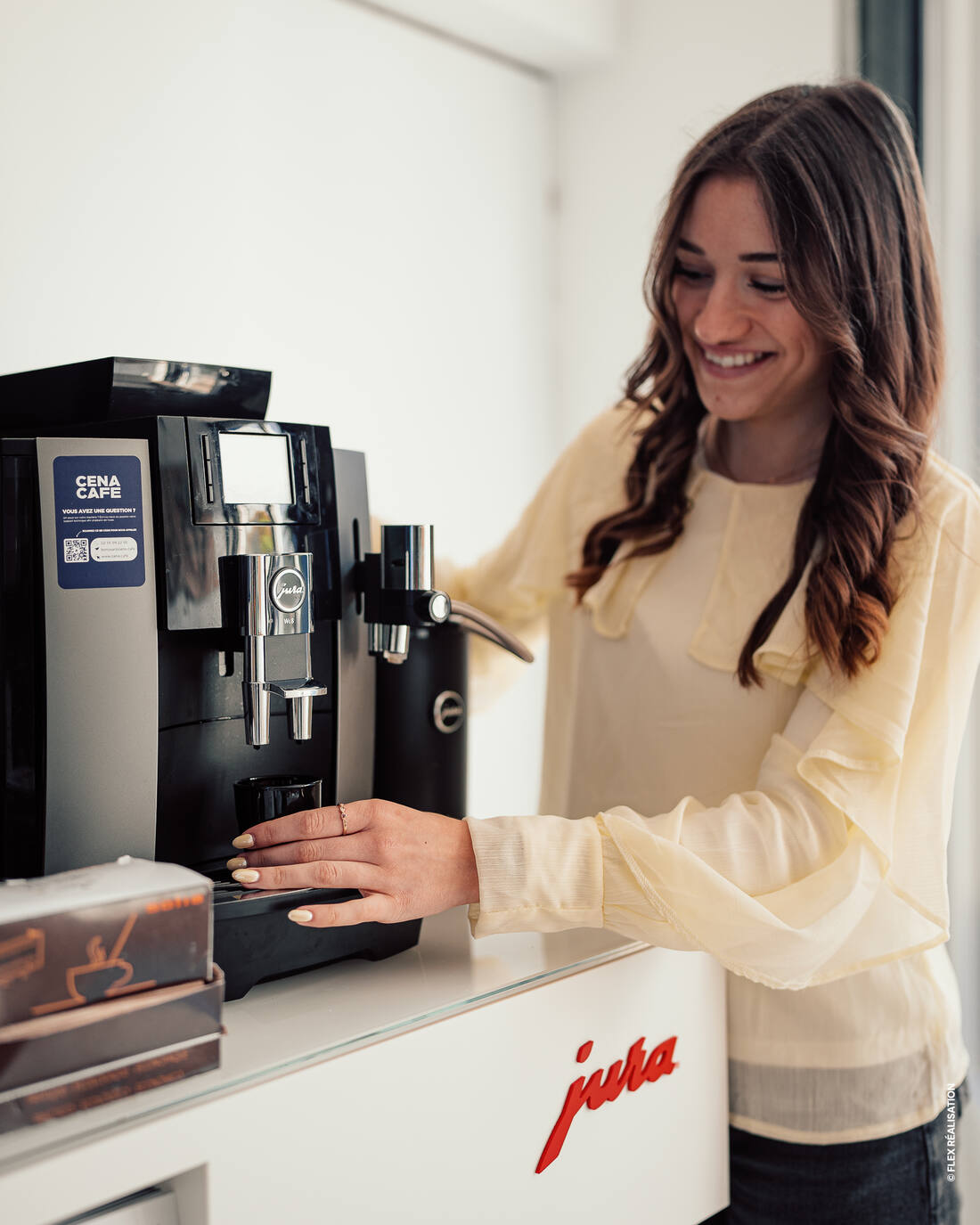 Visiteuse essayant une machine Jura signée Cena Café au showroom d'Orléans